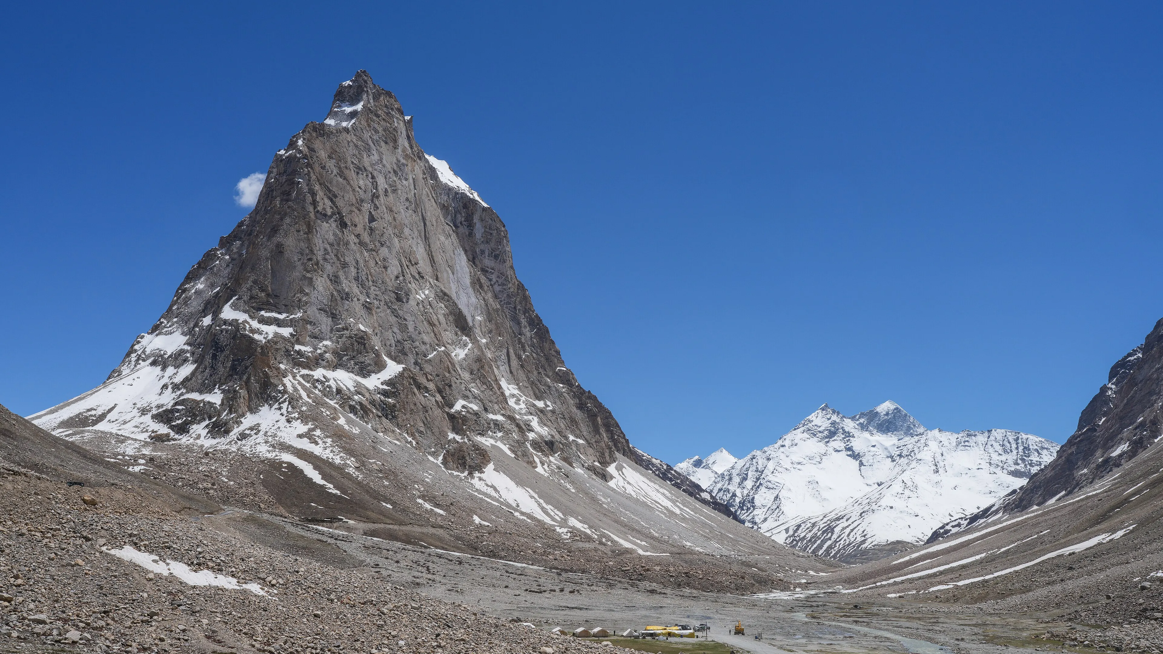 Snow-dusted Himalayan peaks above a high-altitude meadow at first light