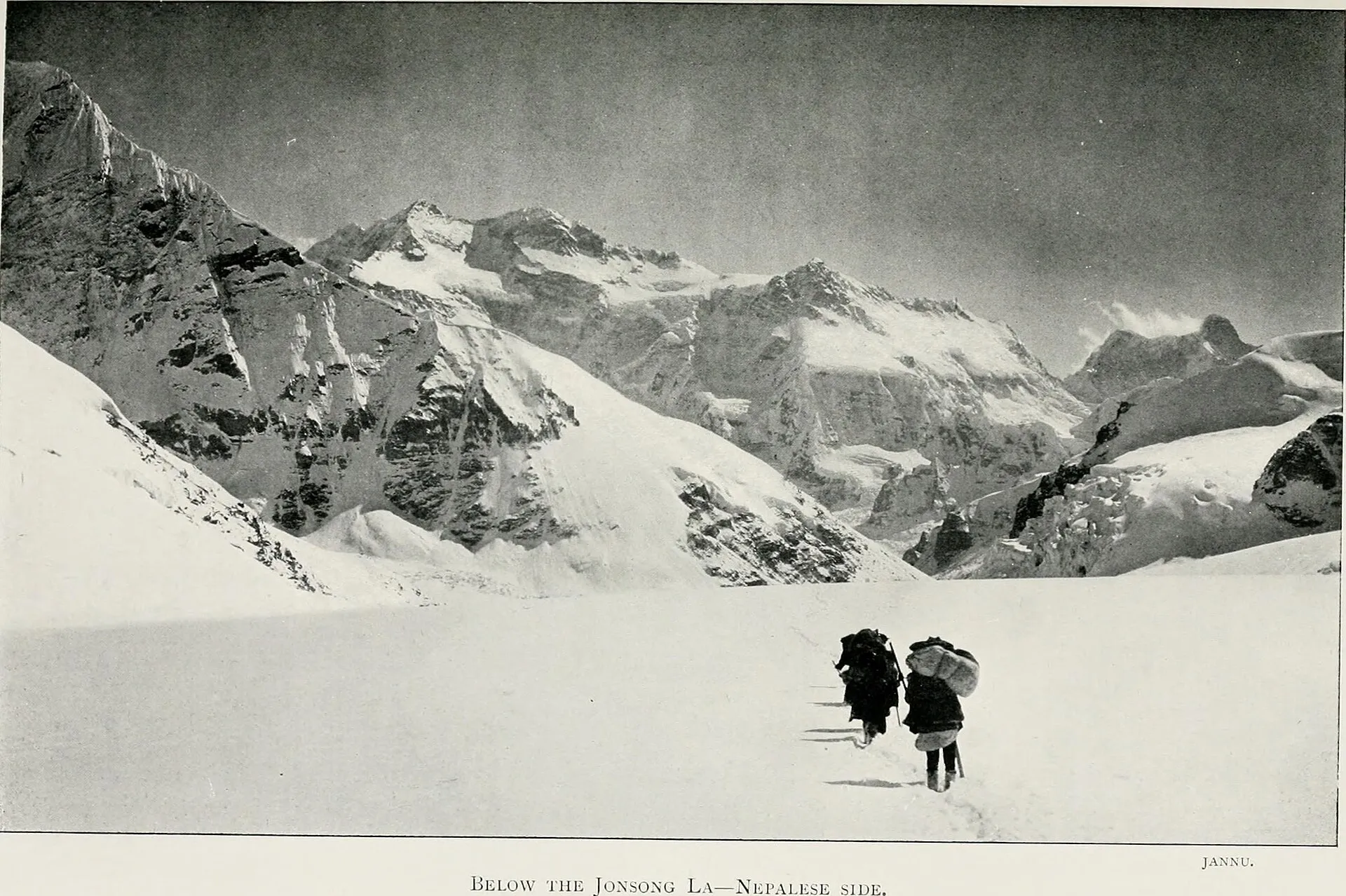A trekker pausing on a Himalayan ridge line surrounded by peaks